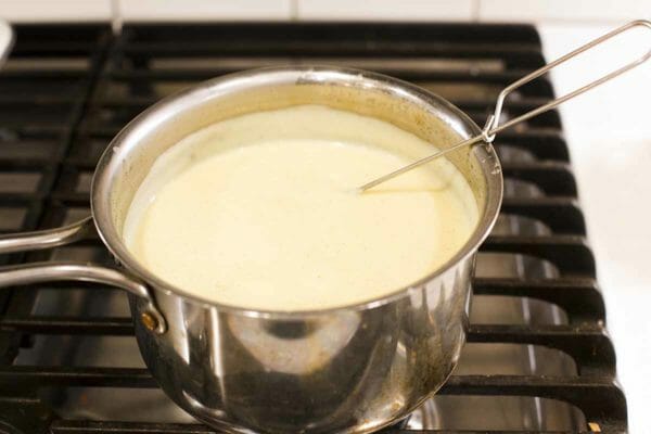A sliver pot filled with vanilla pudding.