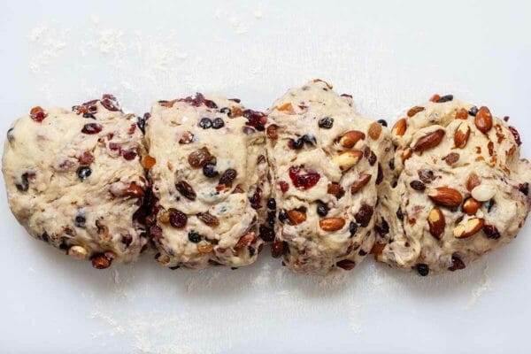 Stollen Christmas Bread dough filled with rum-soaked dried fruit and cut into four equal portions.