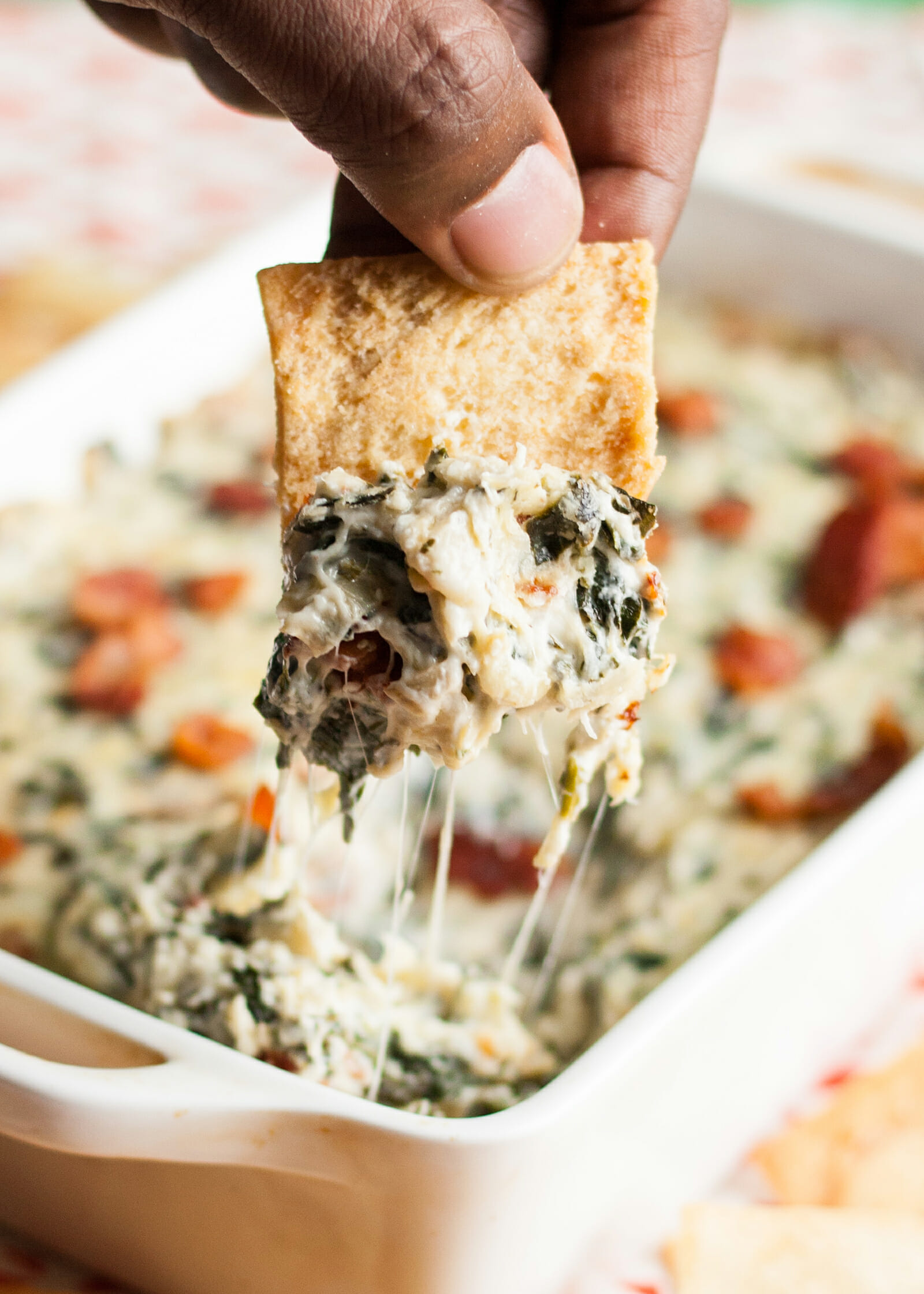 Hot cheesy Spinach Artichoke Dip with Bacon in a white casserole dip