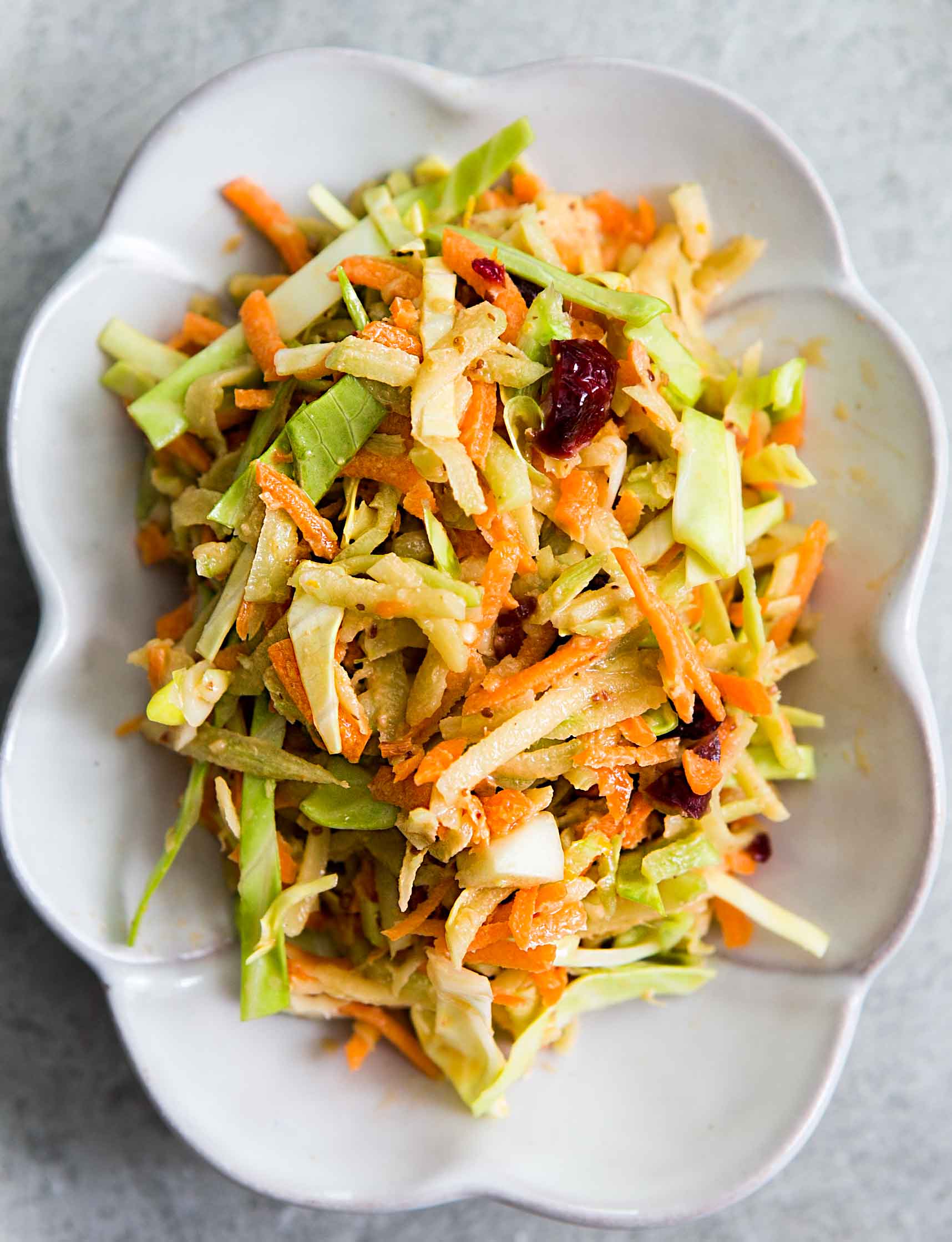 Easy Broccoli Slaw with Cranberry Orange Dressing in a white dish