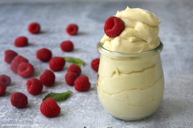 lemon mousse in jar with raspberries on counter