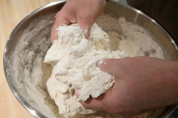 Mix the dough for focaccia bread in the bowl until you've added all the flour