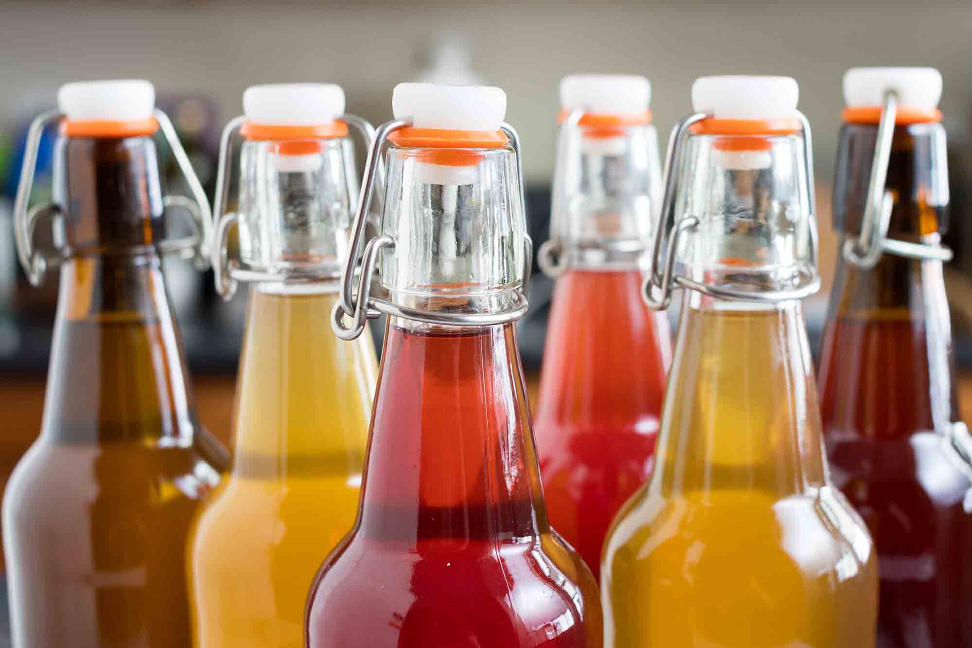 Side view of several bottles filled with kombucha