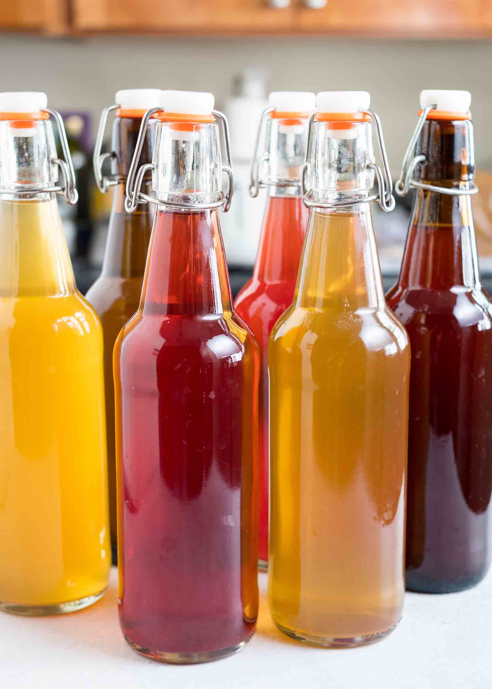 Several filled bottles of homemade kombucha on a counter