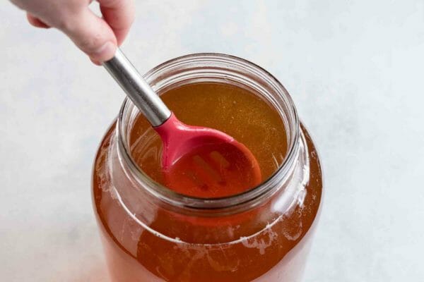 Stir the prepared kombucha, the sweet tea, and the water together in the jar for homemade kombucha