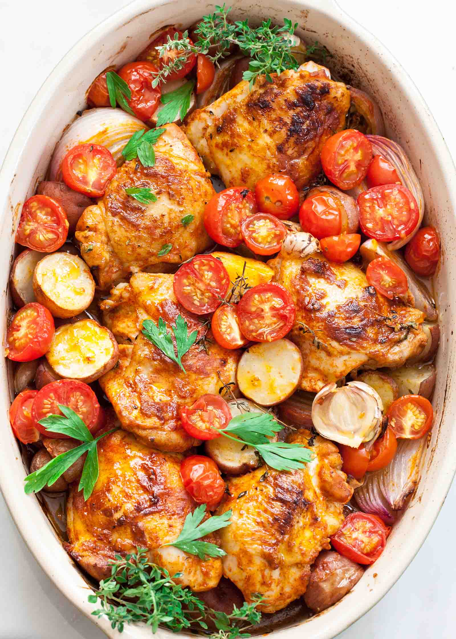Paprika Chicken and Potatoes with Tomatoes in an oval baking dish