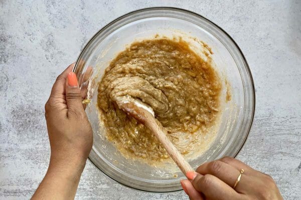 Mixing the Jamaican Banana Bread batter with a wooden spoon.