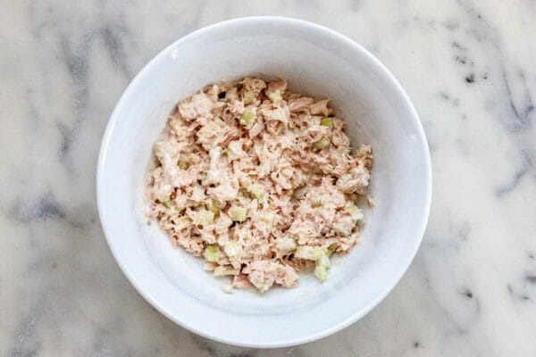 White bowl with filling to make a tuna salad sandwich.