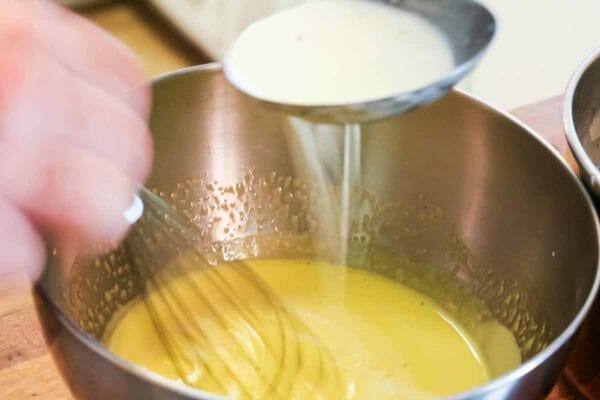 Temper the eggs for vanilla ice cream by pouring a little hot cream into the egg yolks
