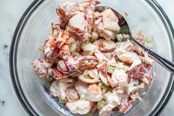 Mixing bowl with creamy lobster salad to make a homemade lobster roll recipe.
