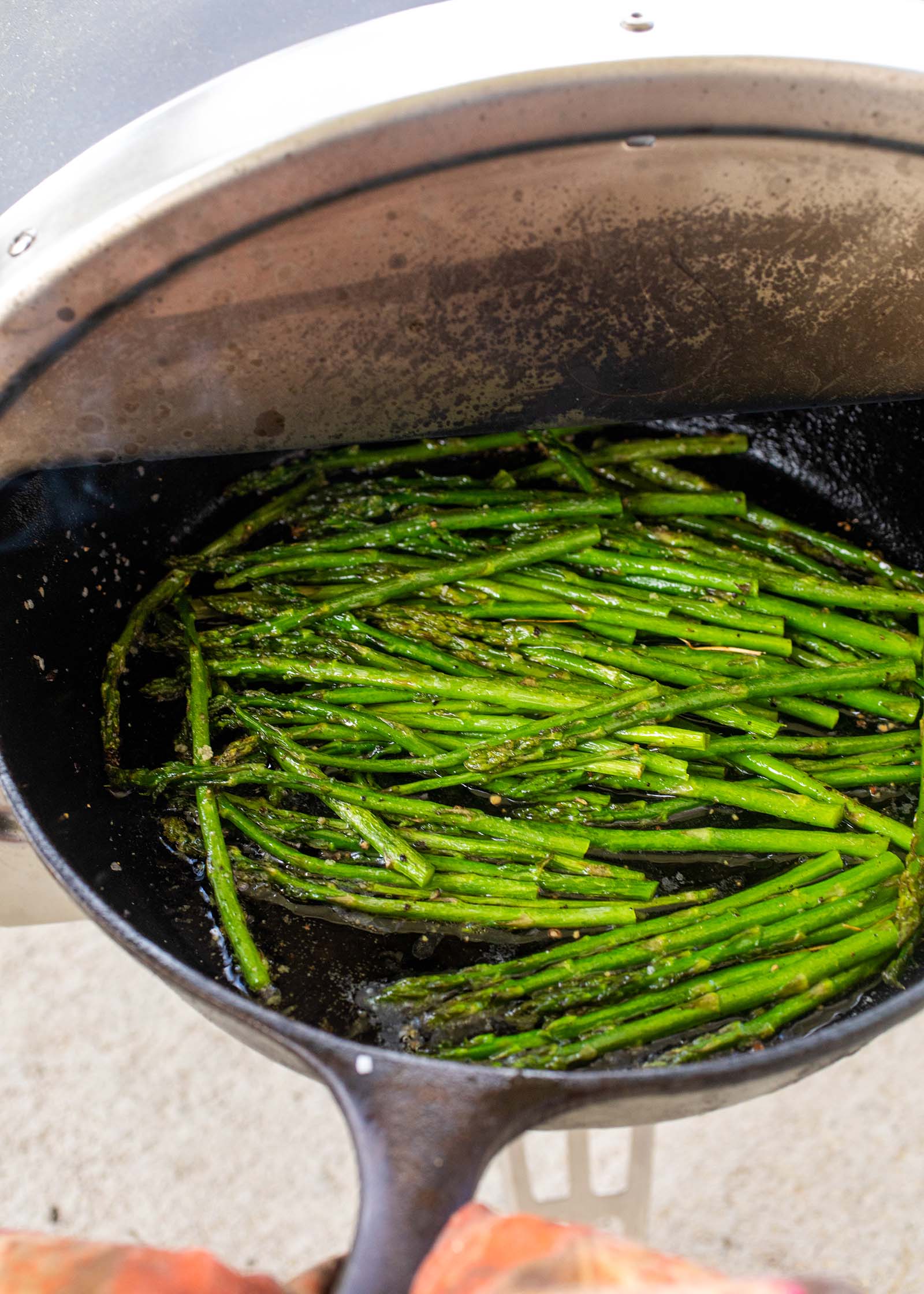 Cast iron skillet with asparagus being cooked inside a roccbox.