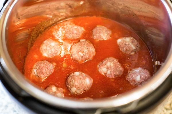 Porcupine meatballs in the pot with tomato sauce.