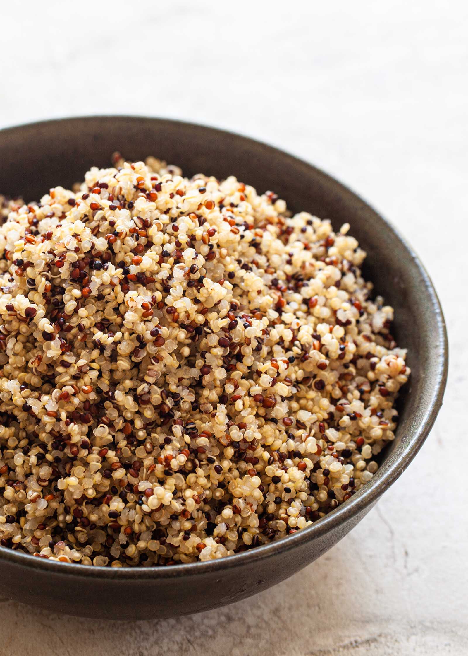 Homemade quinoa recipe in a dark bowl.