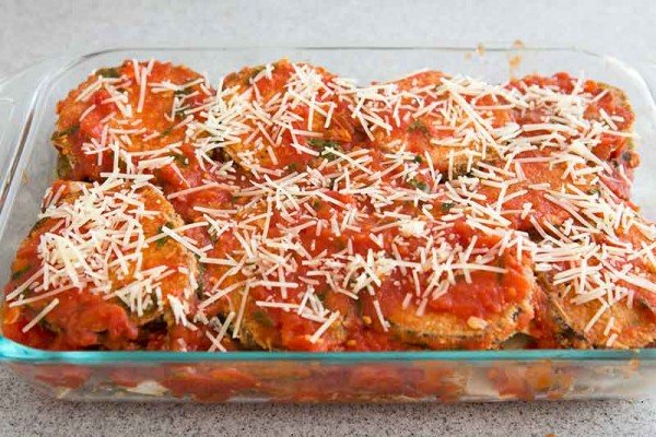 Easy eggplant parmesan layered in a casserole dish and sprinkled with shredded parmesan.